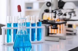 verrerie avec bleu liquide et équipement dans chimie science laboratoire, science et médical recherche et développement concept photo
