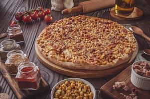 pizza avec mozzarella, maïs, bacon et origan photo