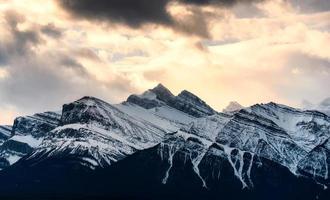 neigeux sommet rocheux montagnes avec lumière du soleil brillant dans région sauvage à nationale parc photo