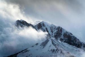 neigeux sommet rocheux montagnes avec lumière du soleil brillant dans région sauvage à nationale parc photo