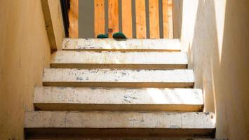 une Jaune escalier avec une en bois clôture et une vert chaussure sur il. photo