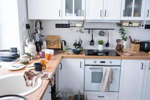 une désordre dans le cuisine, sale vaisselle sur le tableau, épars choses, insalubre conditions. le Lave-vaisselle est complet, le cuisine est désordonné, tous les jours la vie photo