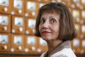 un personnes âgées femme sur le Contexte de bibliothèque cellules. rétro bibliothécaire. photo