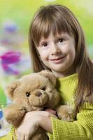 portrait de une magnifique cinq année vieux fille avec une jouet ours. photo