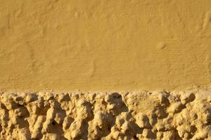 Mur peint en jaune d'une vieille maison fond texturé photo