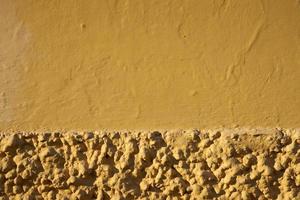 Mur peint en jaune d'une vieille maison fond texturé photo