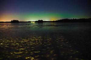 Aurores boréales sur un lac gelé à Littoinen, Finlande photo