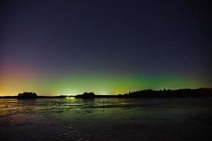 Aurores boréales sur un lac gelé à Littoinen, Finlande photo