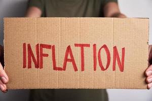 concept d'inflation mondiale. femme tenir feuille avec mot inflation photo