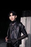 un asiatique homme dans une noir cuir veste posant comme une moto gang photo