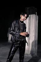 un asiatique homme dans une noir cuir veste posant comme une moto gang photo