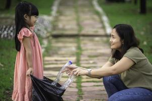 mère et fille asiatiques aident l'environnement caritatif de collecte des ordures. photo