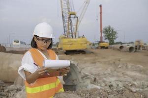 civil ingénieurs travail à une construction chantier, le entreprise directeur supervise le route construction. photo