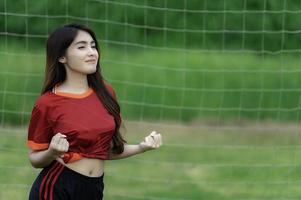 jeune belle femme asiatique porter un joueur de football acclamer le sport, supporters féminins football jeu d'encouragement photo