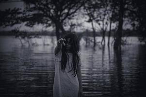 portrait de asiatique femme faire en haut fantôme visage à le marais, horreur dans l'eau scène, effrayant à rivière, halloween affiche, Thaïlande gens photo