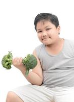 obèse graisse garçon en portant une brocoli haltère isolé photo