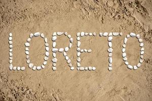 Loreto - mot fabriqué avec des pierres sur le sable photo