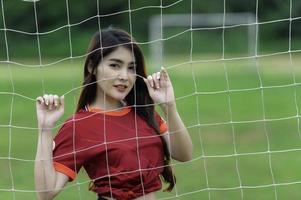 jeune belle femme asiatique porter un joueur de football acclamer le sport, supporters féminins football jeu d'encouragement photo