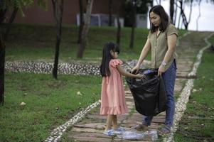 mère et fille asiatiques aident l'environnement caritatif de collecte des ordures. photo