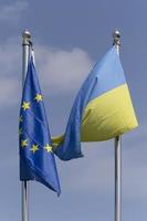 européen syndicat et ukrainien drapeaux pendaison sur mâts de drapeau photo