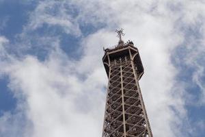 Haut partie de Eiffel la tour contre nuageux ciel photo