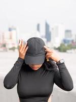 portrait femme fille adolescent Jeune Asie un la personne portant une chapeau et longue noir cheveux portant une noir chemise main tenir fumeur cigarette blanc Couleur permanent Extérieur par le mur Extérieur photo