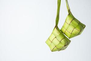 ketupat lebaran est une typique indonésien nourriture pendant le de fête saison de ketupat, eid Al Fitr, eid Al adha, Naturel riz emballage fabriqué de Jeune noix de coco feuilles sur une blanc arrière-plan, vide espace photo