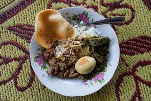 Javanais cuisine nasi rames, nasi camper riz avec du boeuf ragoût, œufs, le Chili, Papaye feuille ragoût, crevette craquelins, photo