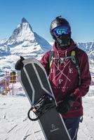 Jeune snowboarder dépenses hiver vacances dans zermatt, près le célèbre Matterhorn culminer. Masculin posant dans Suisse Alpes pour le planche a neige saison. photo