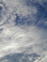 beaux nuages blancs sur fond de ciel bleu profond. de grands nuages doux et moelleux couvrent tout le ciel bleu. photo