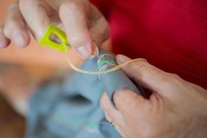 proche en haut de Sénior femme mains Faire broderie sur une tissu photo