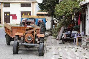 vieux tracteur sur le rue dans le ville. le vieux agricole véhicule, rouillé rouge ancien tracteur, village la vie photo