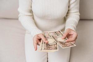 main de femme tenant la pile de billets de banque en yen japonais. mille yens d'argent. trésorerie du japon, impôt, économie de récession, inflation, investissement, finances et concepts de paiement d'achat photo