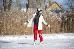 une femme va la glace patinage dans hiver sur un glacé lac. photo