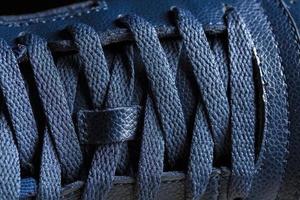 partie de une bleu démarrage avec lacets. une fragment de cuir chaussures. une pièce de espadrille. photo