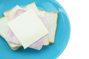 tranche de pain avec fromage et jambon sur bleu assiette avec blanc Contexte photo