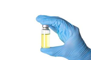 une médecins main dans médical gants détient un ampoule de vaccin. blanc Contexte. copie espace. photo