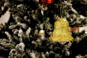 ornement cloche sur Noël arbre avec magnifique bokeh Contexte. photo