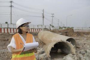 civil ingénieurs travail à une construction chantier, le entreprise directeur supervise le route construction. photo