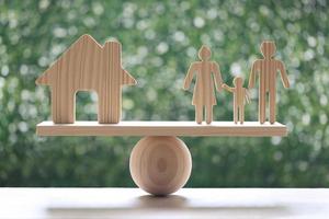 Maison modèle et famille modèle sur balançoire à l'échelle du bois avec fond vert naturel photo