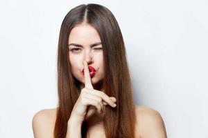 femme secret doigt près lèvres portrait clair peau isolé Contexte photo
