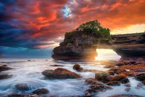 Tanah lot temple sur mer à le coucher du soleil dans bali île, Indonésie. photo