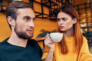 une femme dans une chandail et une homme dans une café une tasse de café couple dans l'amour copains famille photo