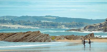 couple de surfeurs en marchant sur le plage. Aller à faire certains surfant photo