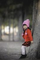 portrait de mignonne asiatique peu fille porter hiver vêtements à le forêt de le parc, Thaïlande gens pose pour prendre une image, heureux temps photo