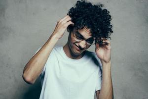 homme avec frisé cheveux portant des lunettes émotions blanc T-shirt studio photo