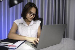 magnifique asiatique femme travail à Accueil sur le nuit, une lot de travail de compagnie, apportez Accueil Travail, travail de Accueil photo