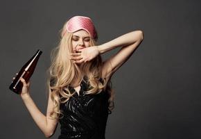 femmes avec une rose sommeil masque détient une bouteille de Bière dans sa main photo