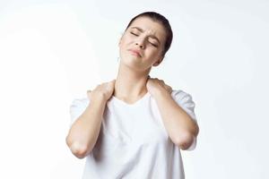 femme dans blanc T-shirt en portant épaules cou douleur santé problèmes malaise photo