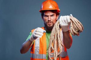 une homme dans une travail uniforme avec une corde dans le sien mains émotions construction mode de vie photo